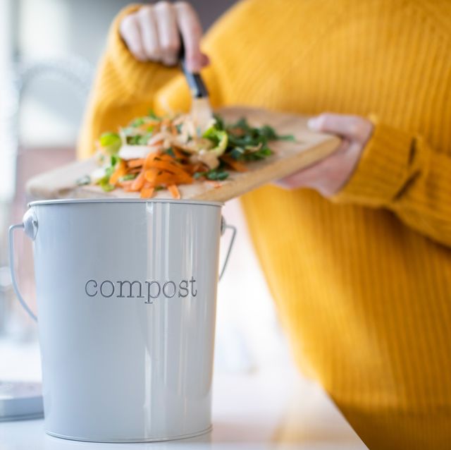 close up of woman making compost from vegetable leftovers in kitchen