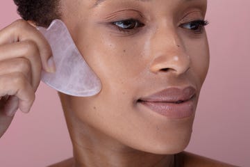 close up of woman massaging face with rose quartz guasha