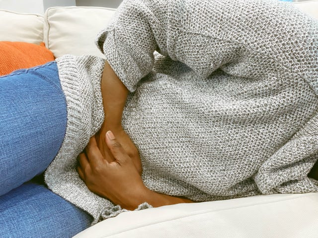 close up of woman on couch with pelvic pain