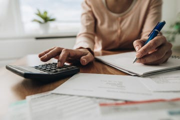 person using calculator to calculate on a car loan
