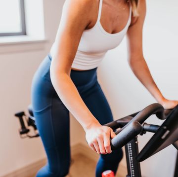 close up of woman riding exercise bike in home gym