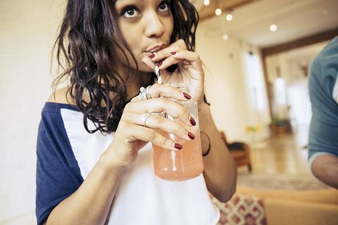woman sipping a cocktail with a paper straw