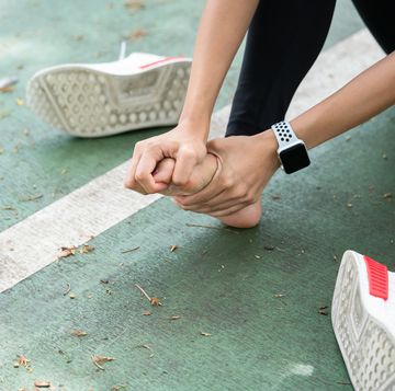 close up of woman stretching bare foot