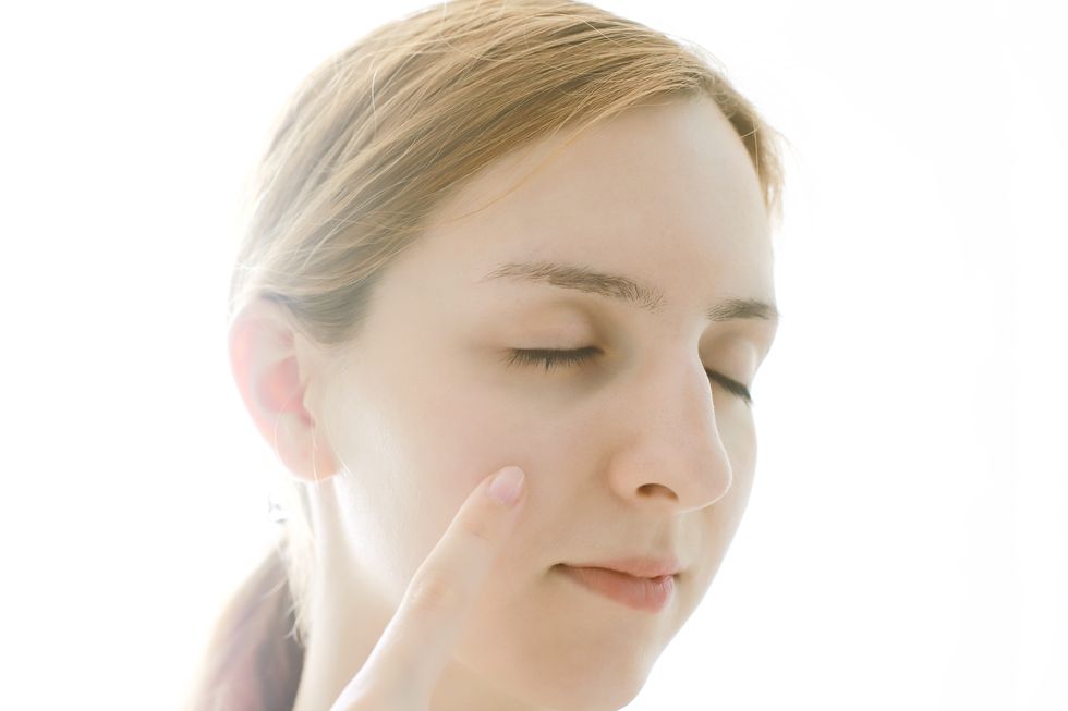 Close up of woman touching face