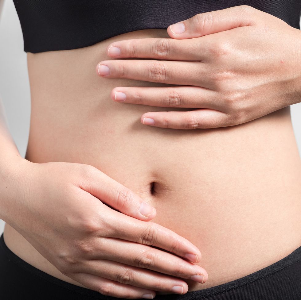 close up of woman touching stomach