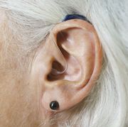 Close-up of woman with gray hair wearing hearing aid