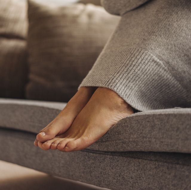 close up of woman's feet sitting on couch