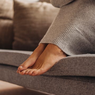 ipercheratosi tallone close up of woman's feet sitting on couch