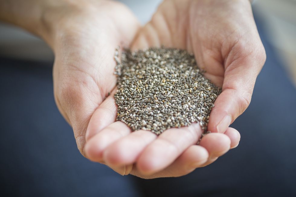 close up of womans hands holding chia seeds