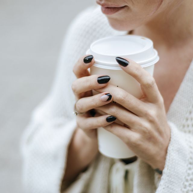 close up of woman's hands with take away drink