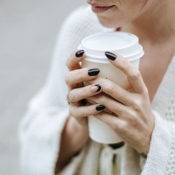 close up of woman's hands with take away drink