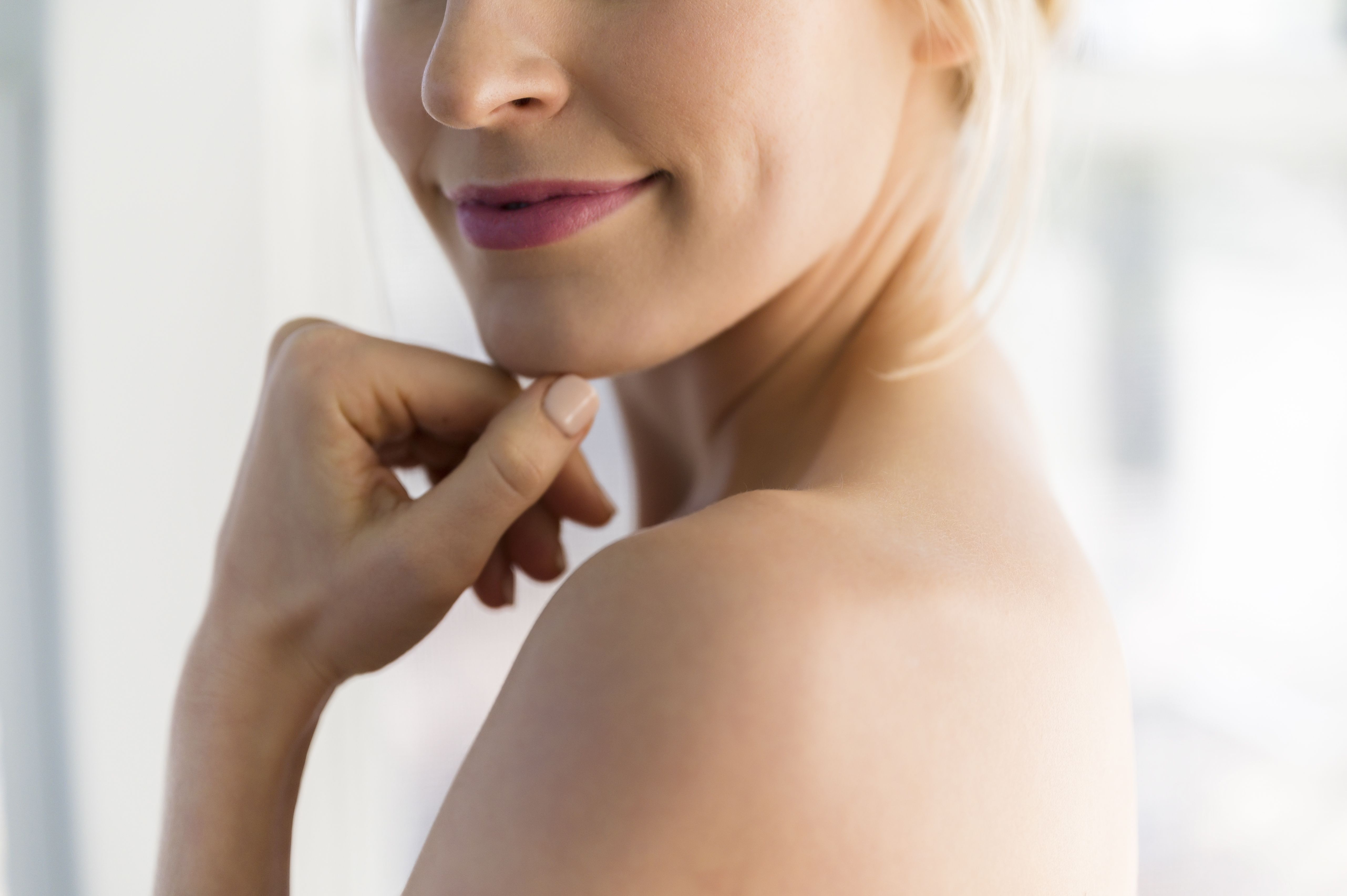 close up of woman's smile and bare shoulder