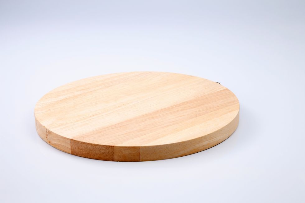closeup of wooden cutting board against white background