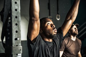 close up of young man training on exercise bar in gymnasium