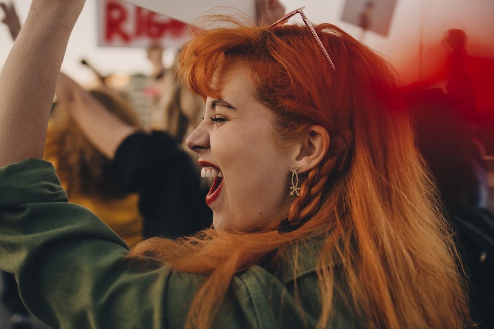 close up of young woman shouting while protesting for rights