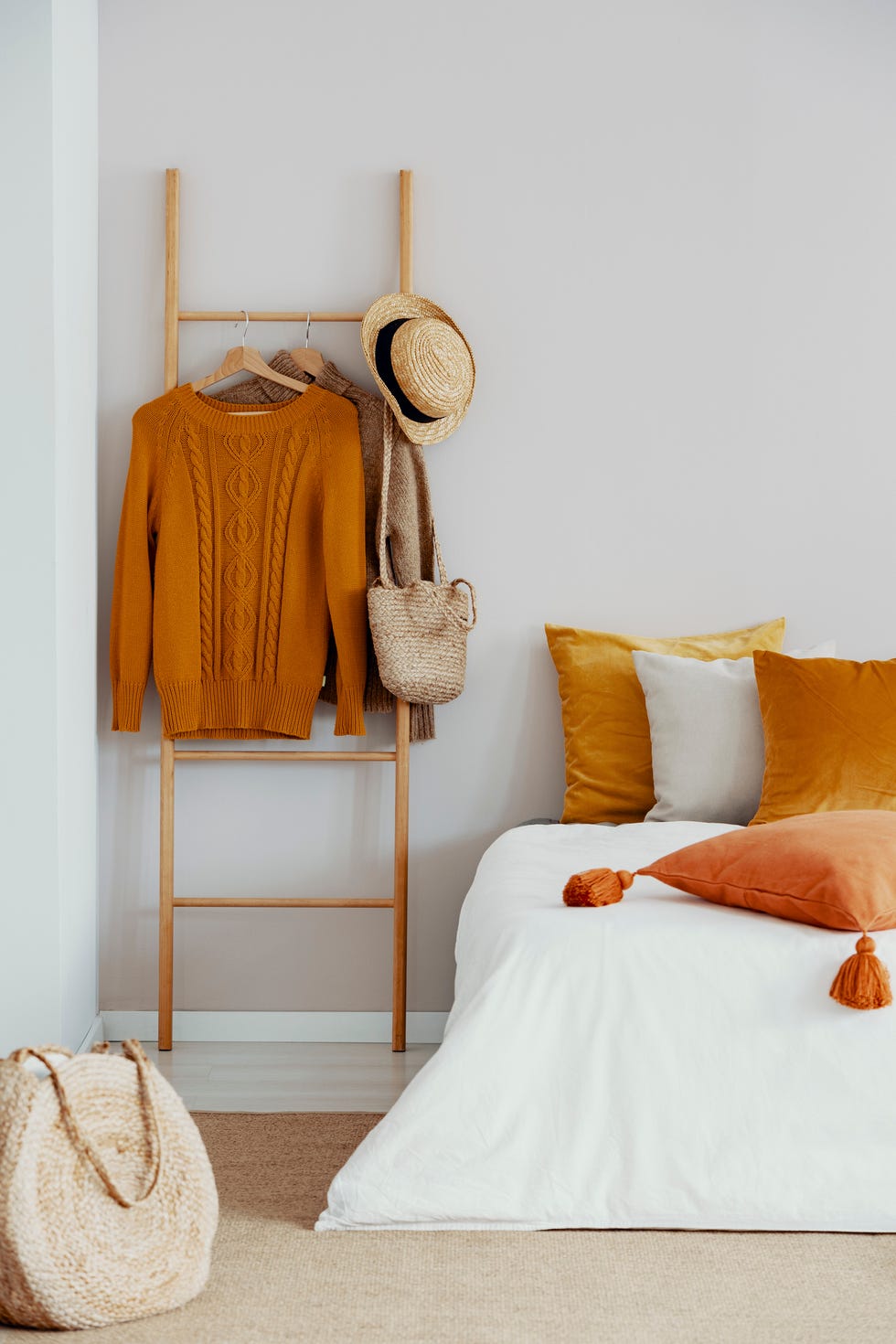 Close up on a bed and wooden decorating ladder with clothes
