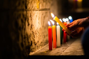 close up on a woman lighting candles during the velitas celebration night