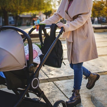 Close up on midsection of unknown caucasian woman mother pushing stroller with baby in the city in day motherhood concept close up on midsection of unknown caucasian woman mother pushing stroller with baby in the city in day motherhood concept
