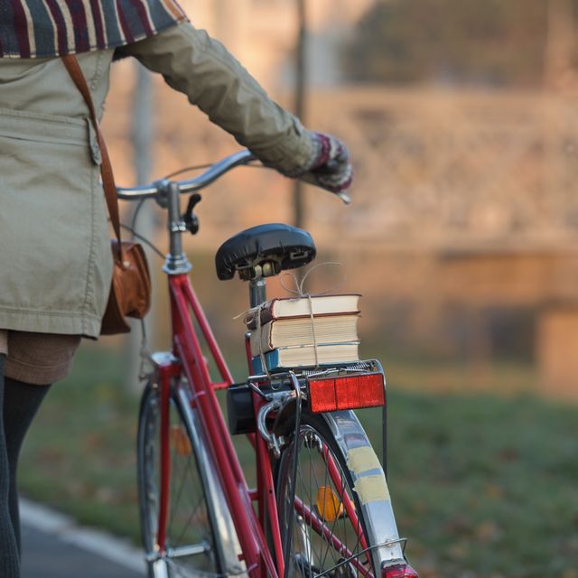 Close up on woman walking along her vintage city bicycle