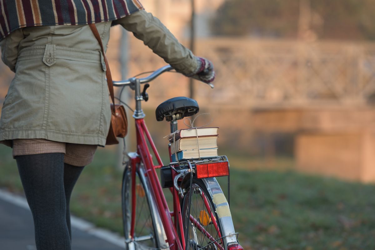 Close up on woman walking along her vintage city bicycle