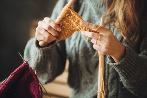 close up on woman's hands knitting