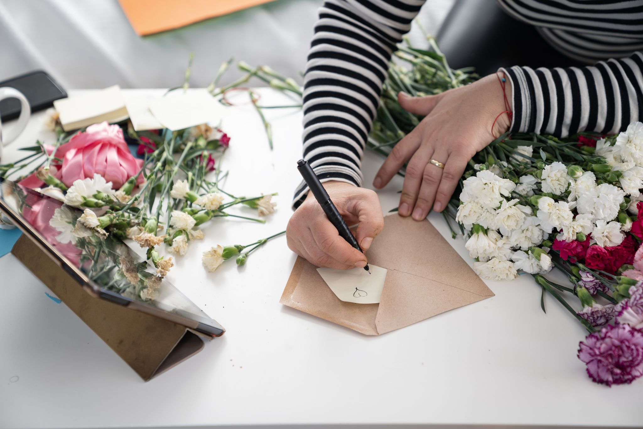 woman writing note with flowers