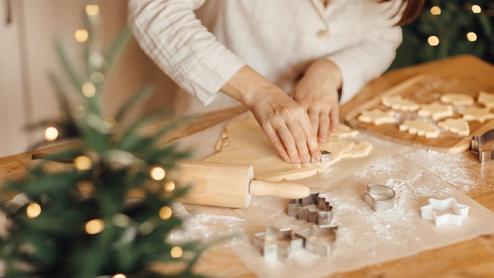 close up photo of woman's hand making holiday cookies at home