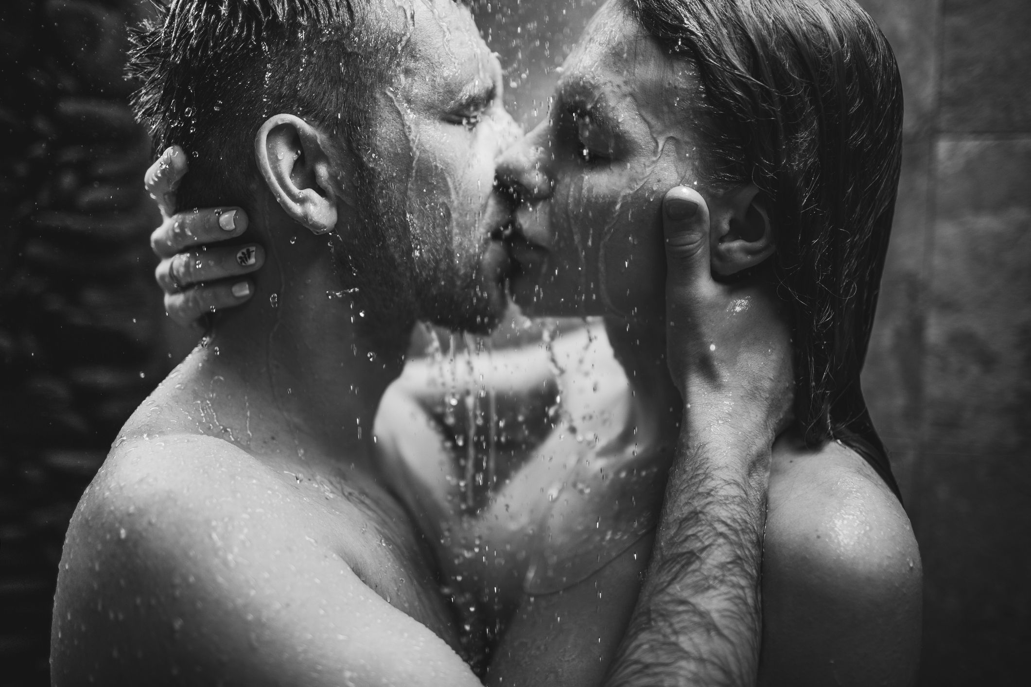 close up portrait of couple in love kissing under tropical shower with passion intimate, togetherness and romantic black and white