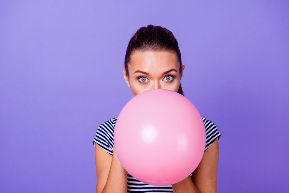 close up portrait of her she nice attractive lovely charming cute winsome girl blowing big large pink helium ball isolated over violet purple vivid shine bright background