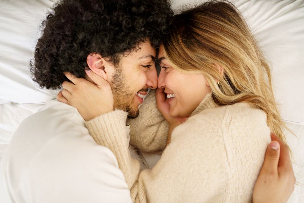 close up portrait of young diversity couple kissing on the bed