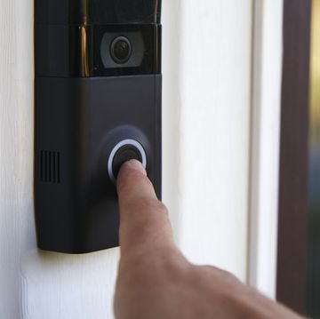 close up pov shot of a person ringing a smart doorbell