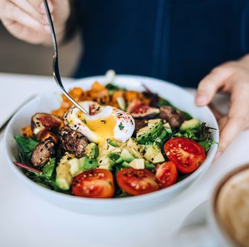 close up shot of a woman eating a dish of fresh beef cobb salad with a soft boiled egg and coffee at a cafe table. enjoying her healthy and nutritious lunch. maintaining a healthy and well balanced diet. the concept of healthy eating lifestyle