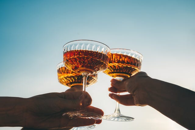 Close Up Glasses Of Clinking Glasses Of Champagne With Lighting