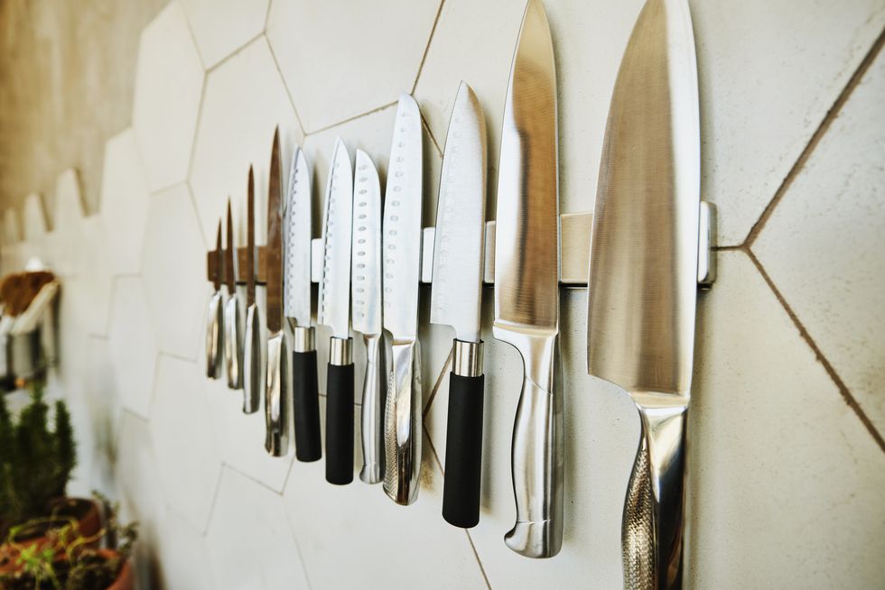 close up shot of kitchen knives on wall in kitchen
