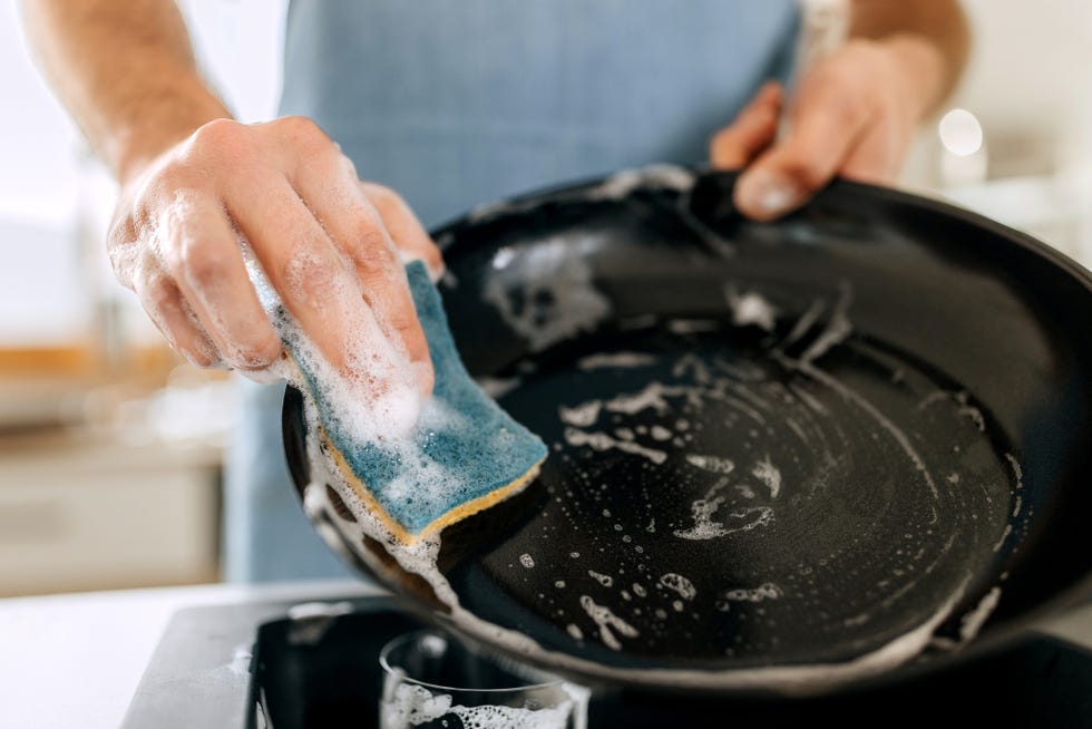 close up shot of man washing cooking pan
