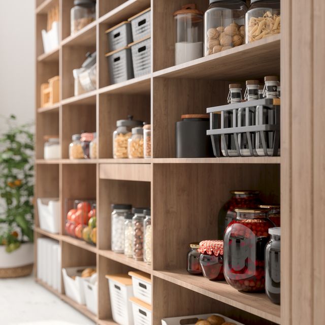 close up view of organised pantry items with variety of nonperishable food staples and preserved foods in jars on kitchen shelf