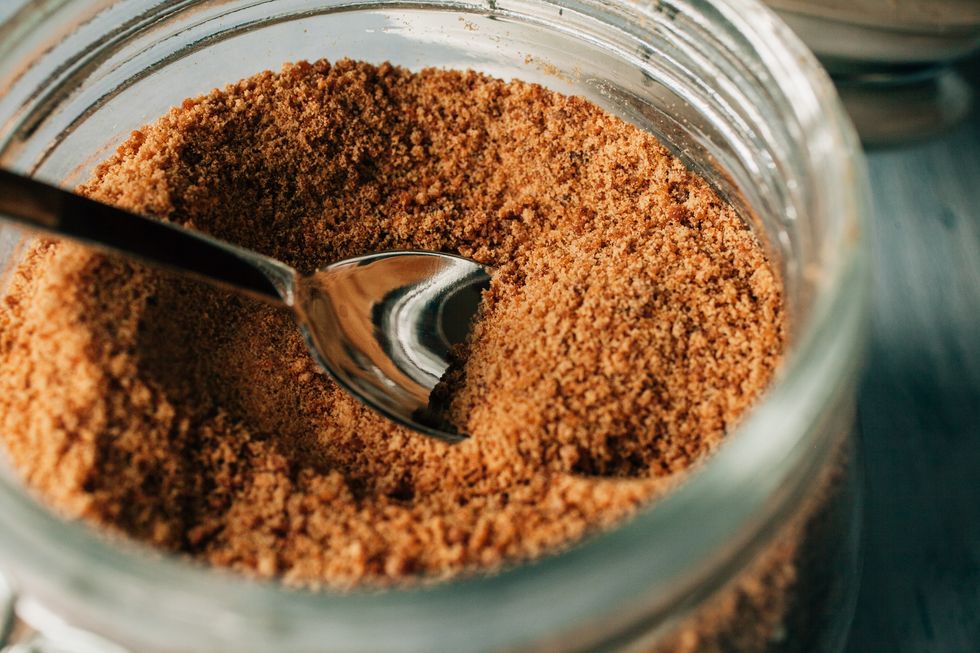 close up view of raw cane sugar in a jar panela brown sugar as background organic and healthy food