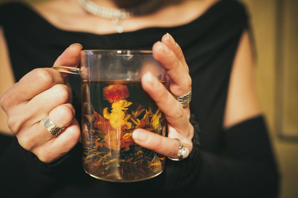 woman drinking blooming flower tea