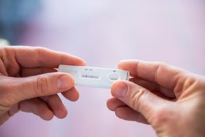 close up woman hands holding rapid covid 19 test with a positive result self express coronavirus testing at home covid 19 test kit for detecting igm igg antibodies and immunity selective focus
