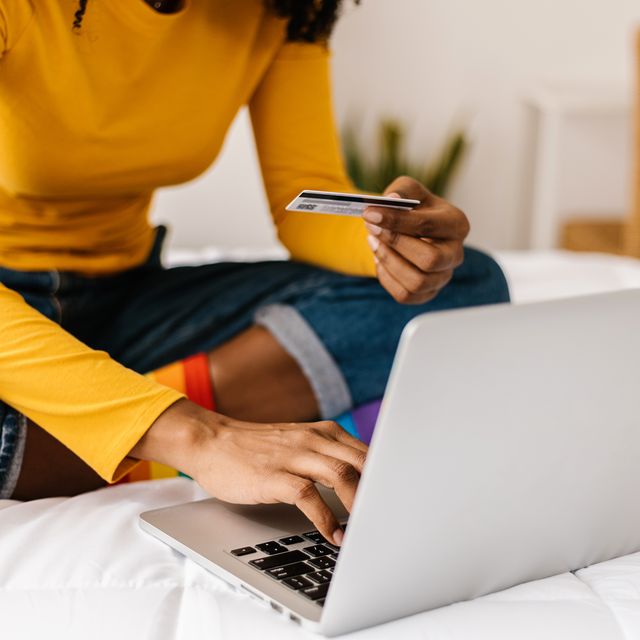 close up woman hands using credit card to buy online on laptop