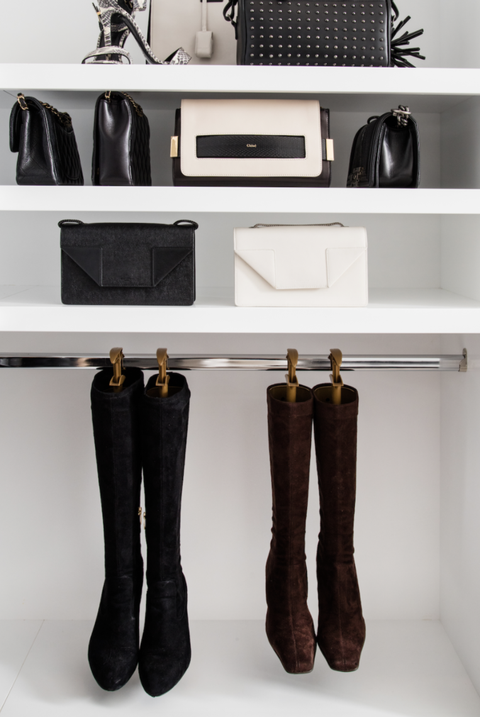 closet organization ideas, boots hanging from a rod with purses on the white shelves