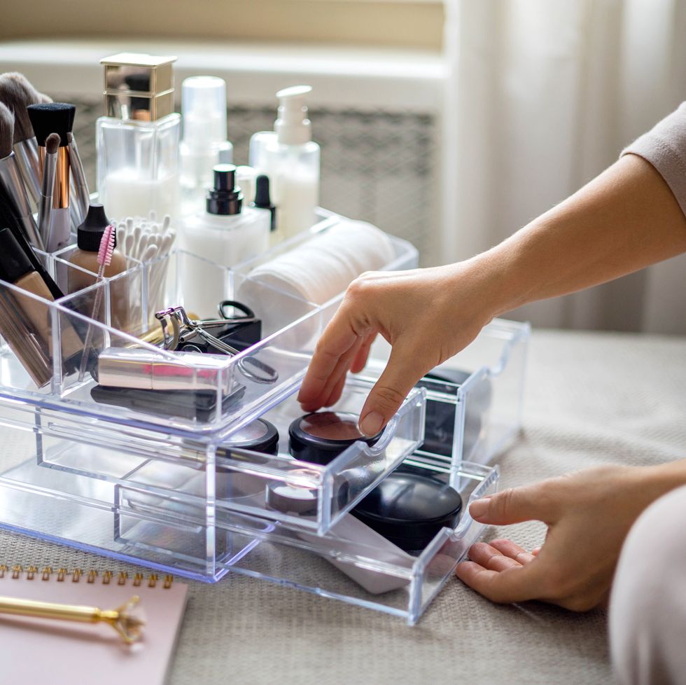 closeup female hands putting luxury cosmetic into acrylic box with drawer storage organization