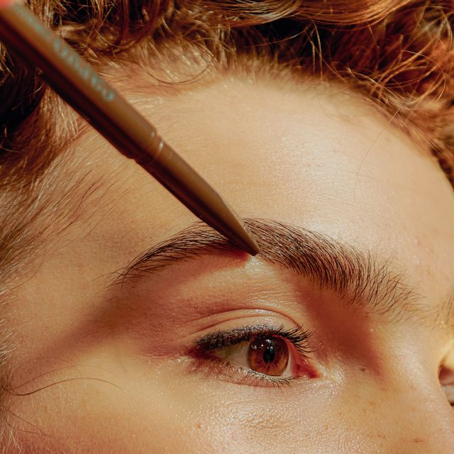 closeup of a young confident woman filling in her eyebrows