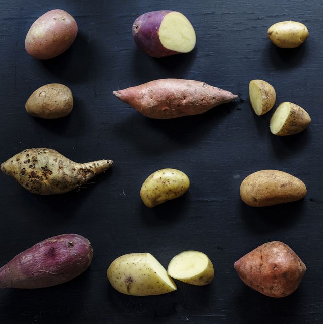 Closeup of fresh various organic potatoes on black background