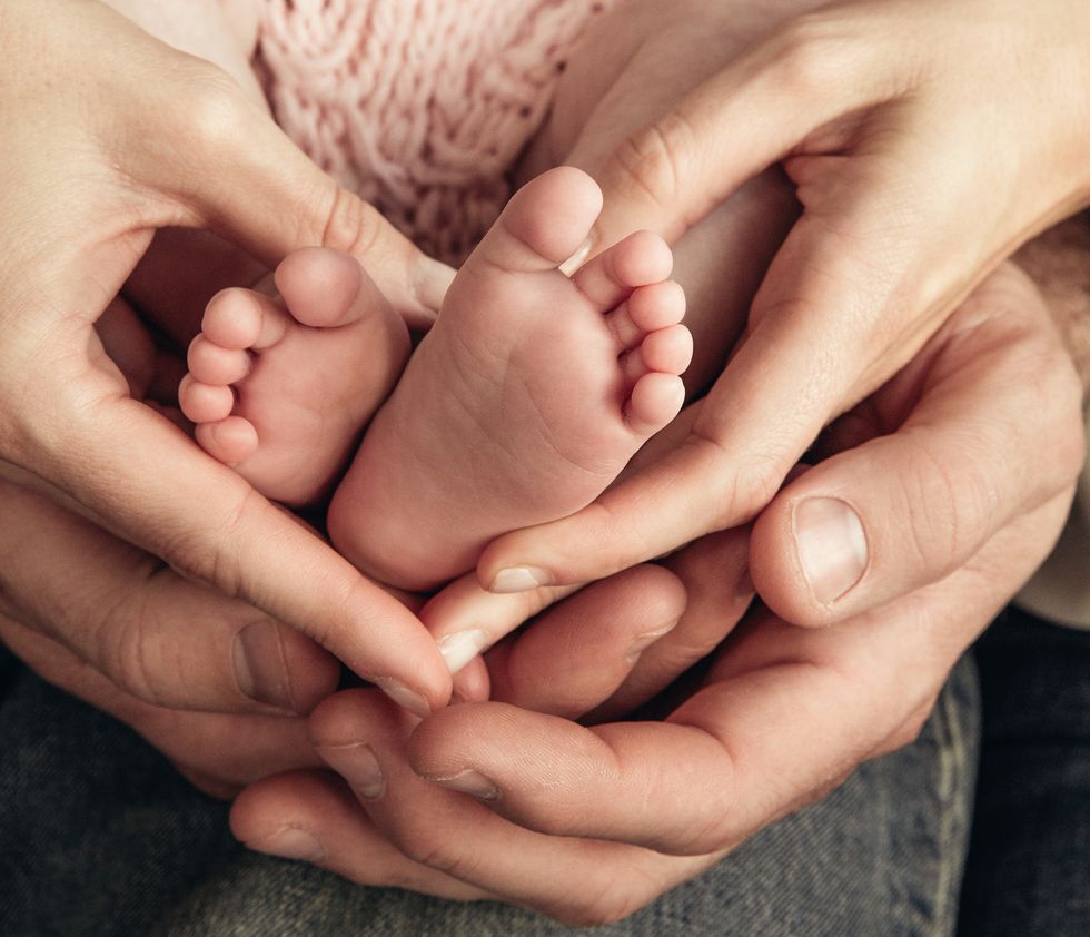 closeup of hands holding baby's feet