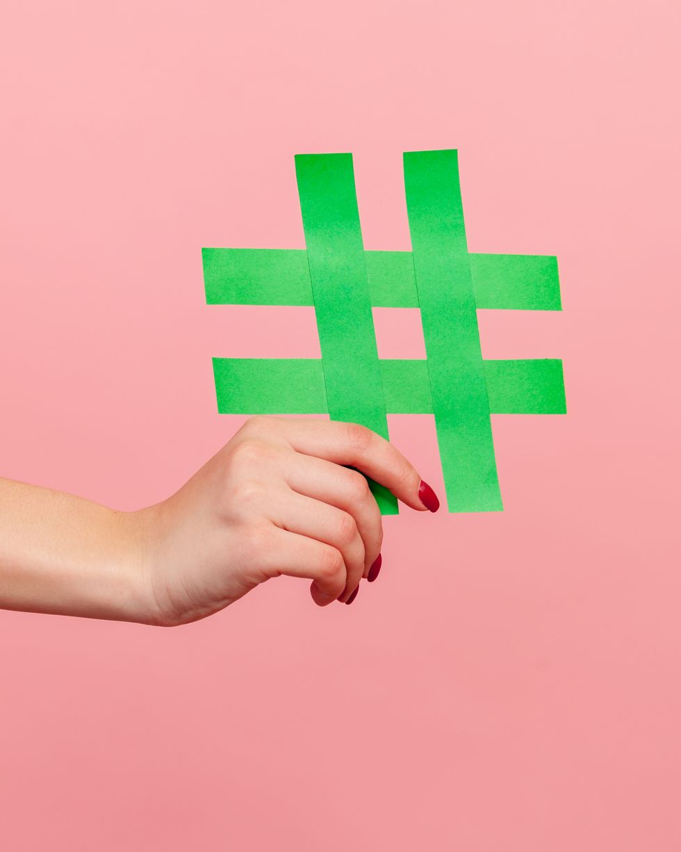 closeup of yellow hash sign, female hand holding paper hashtag, symbol of social network trends and popular comments, famous blog content, promotion