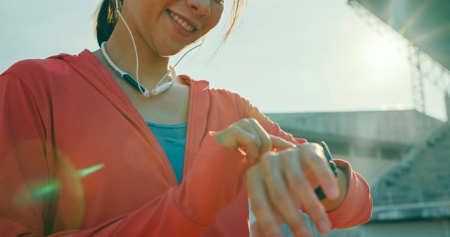 vrouw checkt haar horloge voor het lopen van een halve marathon