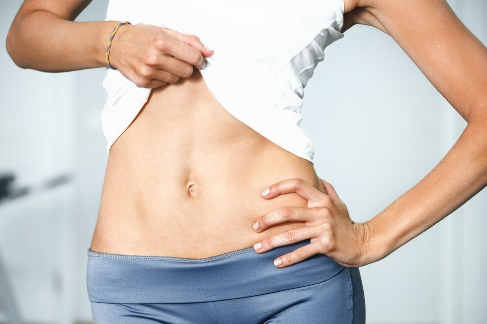 closeup of young slim woman with six pack torso