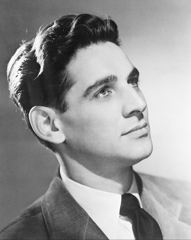 a black and white photograph closeup of leonard bernstein, wearing a suit and looking off camera