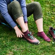 woman wearing hiking socks and putting on a pair of hiking shoes